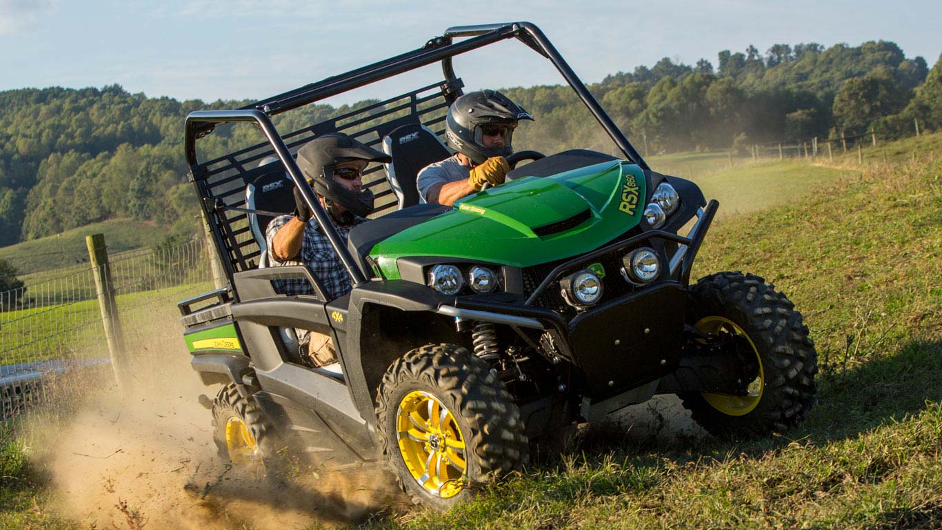 Picture shows two men with helmets riding in their Gator RSX.