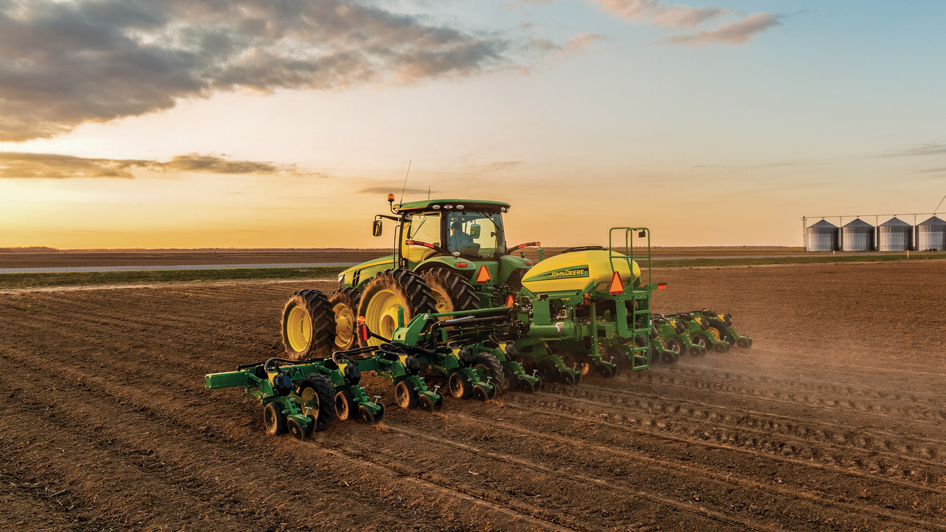 A John Deere tractor and planter in an open field. The blog discusses COVID-19 adaptions happening in Reynolds stores.